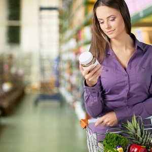 ragazza al supermarket legge un'etichetta alimentare 